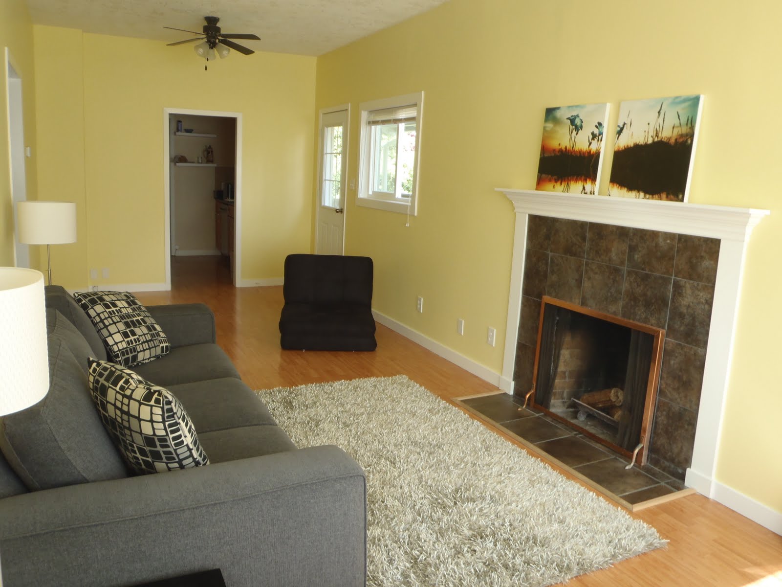 real photo of yellow walls + grey sofa + grey rug Living room
