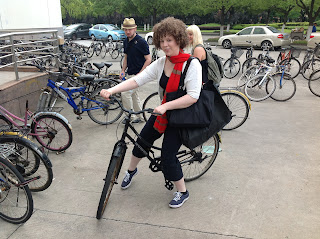 a student sits on a bicycle