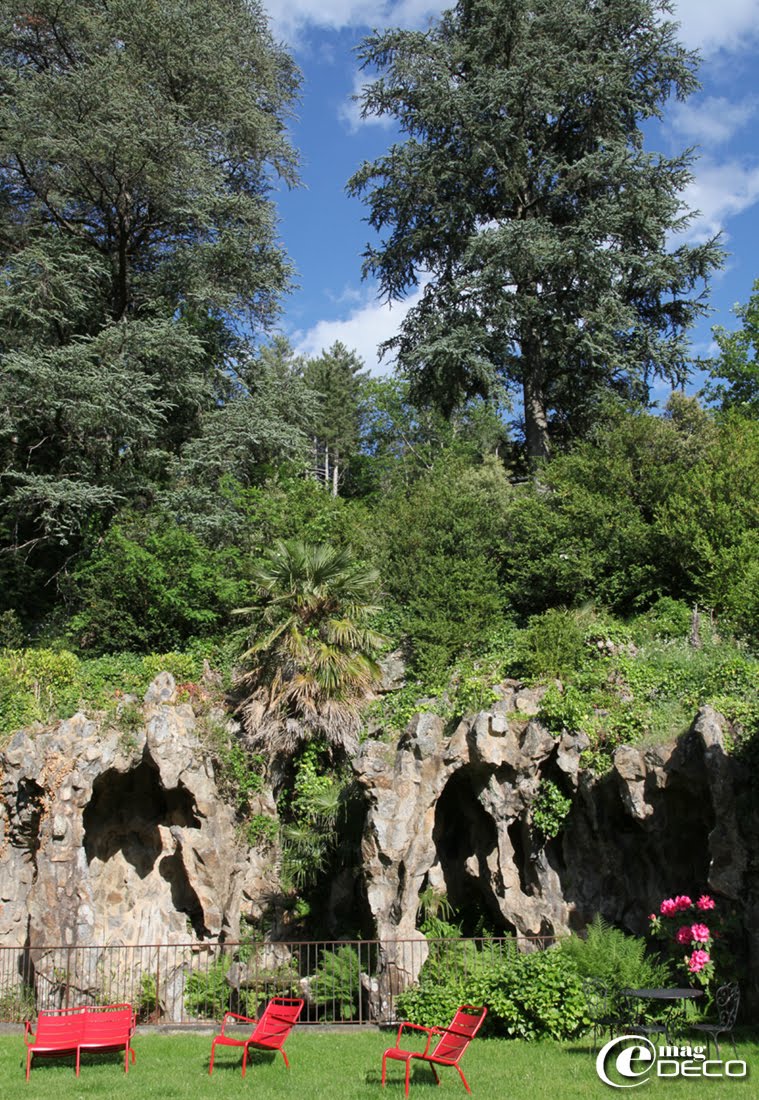 Devant la grotte du Château Clément à Vals-les-Bains, des fauteuils bas simples et duo modèle 'Luxembourg' de la marque 'Fermob'