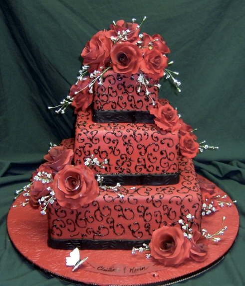 A stunning five tier wedding cake in red and black with sugar roses