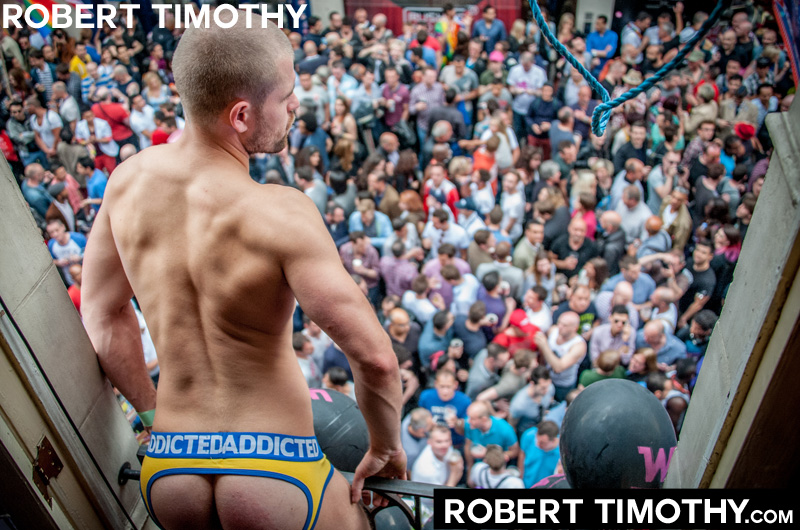 Man wearing a Addicted jockstrap hangs out of the window of Comptons gay bar on Old Compton Street during World Gay Pride festivities in London