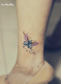 a pink and blue butterfly tattoo on the leg
