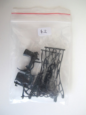 Plastic bag containing parts of a dolls' house miniature vintage sewing machine kit.