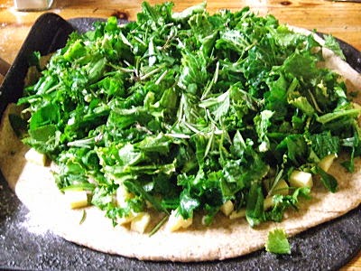 chopped, seasoned perennial vegetable greens piled on pizza dough