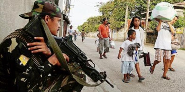 AP Photo/Bullit Marquez Tentara Filipina berjaga-jaga di kota Zamboanga, Filipina selatan, saat warga berbondong-bondong meninggalkan tempat tinggal mereka menyusul ketegangan antara gerilyawan pemberontak dan pasukan pemerintah yang memasuki hari kedua, Selasa (10/9). Sekitar 200 gerilyawan menjadikan penduduk sebagai perisai manusia di desa-desa tersebut. | AP Photo/Bullit Marquez