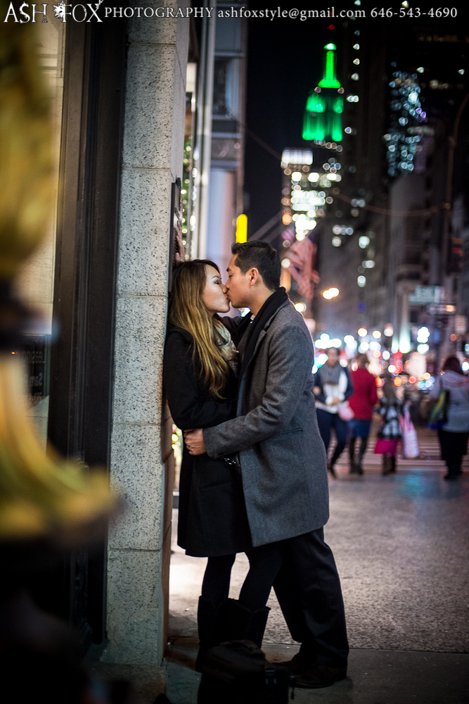 Kissing with the Empire State building in the background around holiday season after an epic proposal
