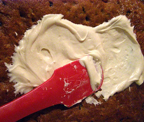 Spatula spreading frosting over bars