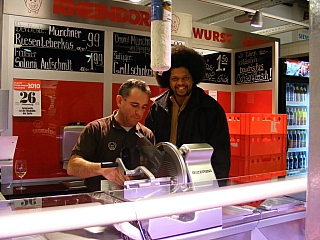 A customer looking on as the shopkeeper packs his meat to avoid being cheated A customer looking on as the shopkeeper packs his meat to avoid being cheated