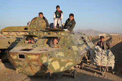 Afghan children play over the wreckage of an old Soviet-era tank in Ghazni on November 15, 2013. Tens of thousands of children in Afghanistan, driven by poverty, work on the streets of the war-torn country's cities and often fall prey to Taliban bombings and other violence, as well as abuse