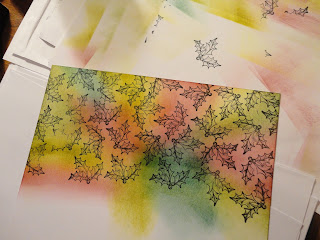 Coloured ink background stamped with black holly images