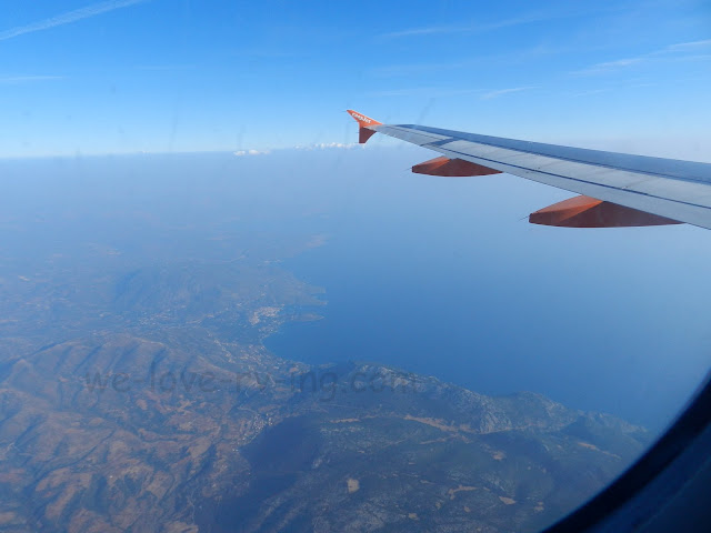 The rugged countryside of Greece can be seen out the airplane window.