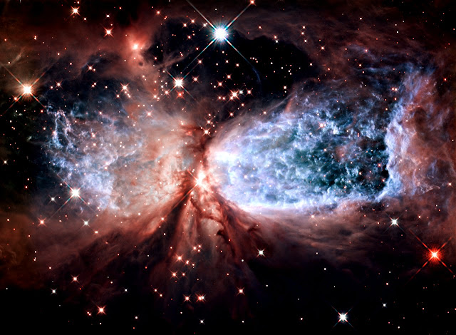 The bipolar star-forming region, called Sharpless 2-106, looks like a soaring, celestial snow angel. The outstretched "wings" of the nebula record the contrasting imprint of heat and motion against the backdrop of a colder medium.  Sharpless 2-106, Sh2-106 or S106 for short, lies nearly 2,000 light-years from us. The nebula measures several light-years in length. It appears in a relatively isolated region of the Milky Way galaxy.  A massive, young star, IRS 4 (Infrared Source 4), is responsible for the furious activity we see in the nebula. Twin lobes of super-hot gas, glowing blue in this image, stretch outward from the central star. This hot gas creates the "wings" of our angel.  A ring of dust and gas orbiting the star acts like a belt, cinching the expanding nebula into an "hourglass" shape. Hubble's sharp resolution reveals ripples and ridges in the gas as it interacts with the cooler interstellar medium.  Dusky red veins surround the blue emission from the nebula. The faint light emanating from the central star reflects off of tiny dust particles. This illuminates the environment around the star, showing darker filaments of dust winding beneath the blue lobes.  Detailed studies of the nebula have also uncovered several hundred brown dwarfs. At purely infrared wavelengths, more than 600 of these sub-stellar objects appear. These "failed" stars weigh less than a tenth of our Sun. Because of their low mass, they cannot produce sustained energy through nuclear fusion like our Sun does. They encompass the nebula in a small cluster.  The Hubble images were taken in February 2011 with the Wide Field Camera 3. Visible narrow-band filters that isolate the hydrogen gas were combined with near-infrared filters that show structure in the cooler gas and dust.  Image Credit: NASA, ESA, and the Hubble Heritage Team (STScI/AURA)Explanation from: http://hubblesite.org/newscenter/archive/releases/2011/38/image/a/