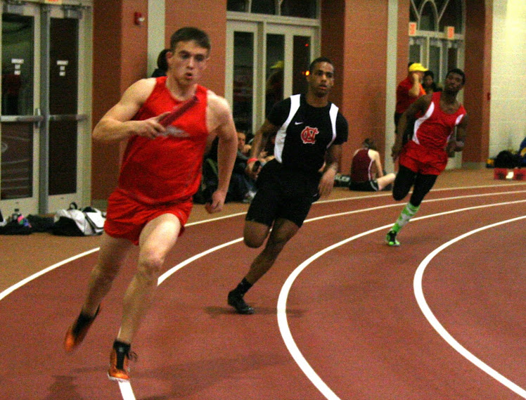 North Central runner, middle, navigates the curve during a relay.