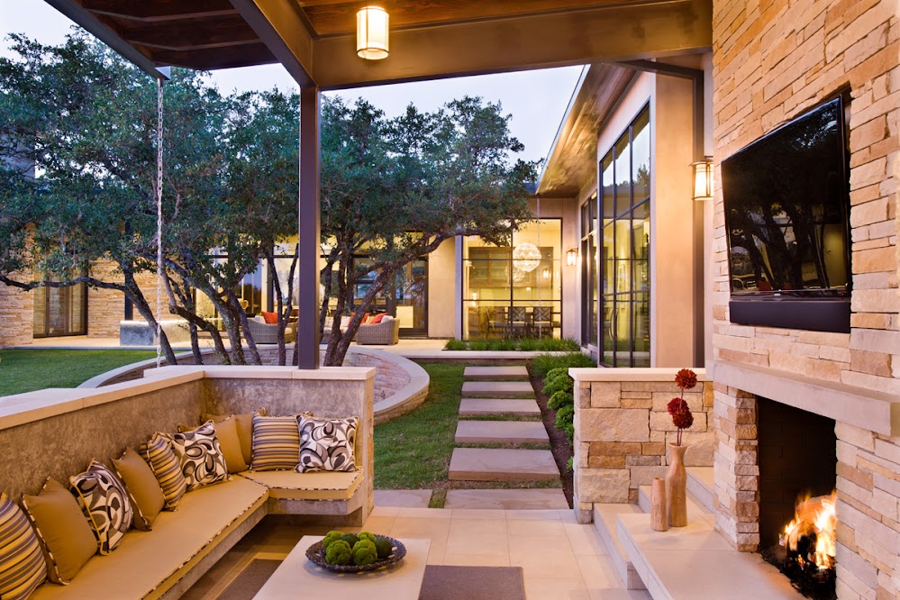 Photo of covered outdoor terrace with the fireplace, tv and siting are with small pillows