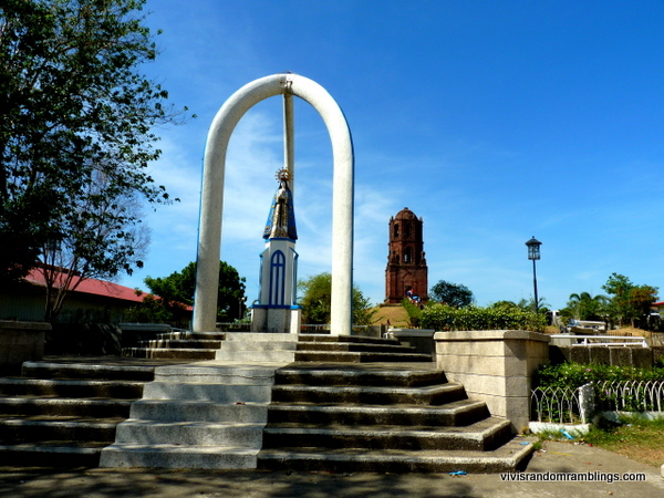 the statue of Our Lady of Charity, who is Nueva Segovia’s patroness and the Bell Tower in the background