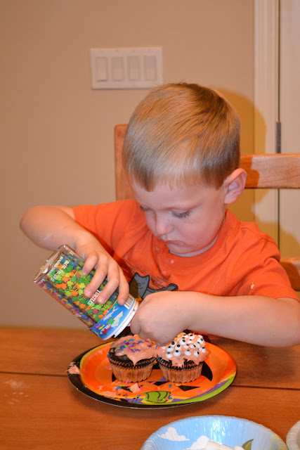 Carter decorating Halloween cupcakes