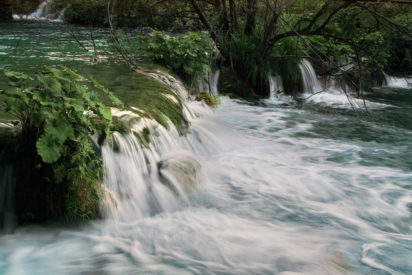 Foto de uma cascata mostrando e efeito da velocidade da água pela desfocagem originada por baixa velocidade do obturador da câmara fotográfica