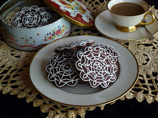 doily with decorated dark-chocolate tea biscuits