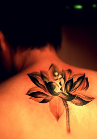 A golden and shining lotus flower tattoo on the back