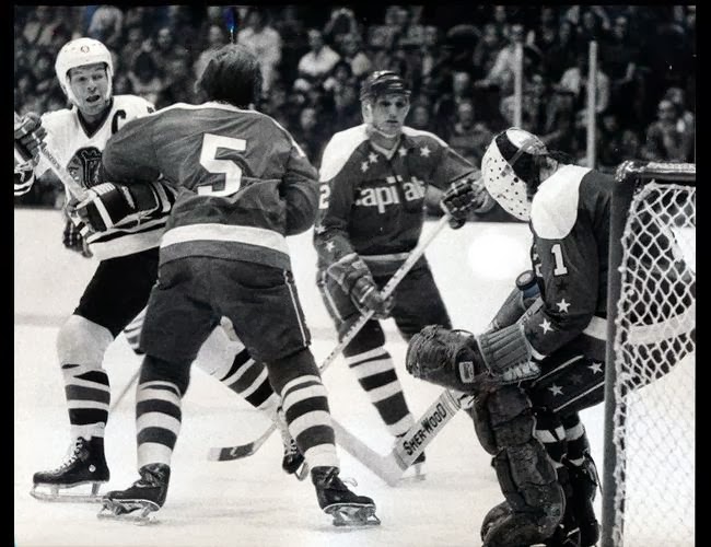  Vs. Chicago: Willy Brossart (5), Jack Lynch (2) defend, as Ron Low makes the save; Caps won 7-5, the first W of their 2nd season (10/26/75)