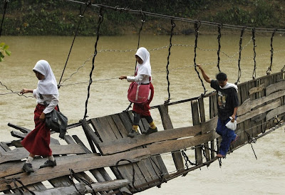 Indonesian children make perilous journey to school over collapsed bridge