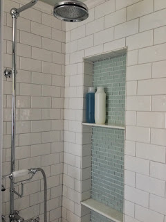 shower niche with glass tiles and exposed shower faucet in master bath via www.goldenboysandme.com
