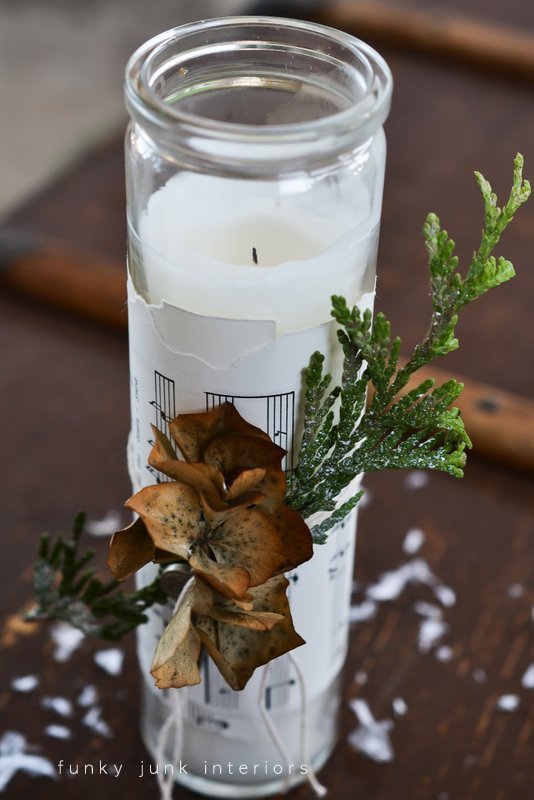 candle wrapped with greens, hydrangeas and key