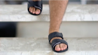 Os pés masculinos do ator Thiago Lacerda usando chinelos Cartago