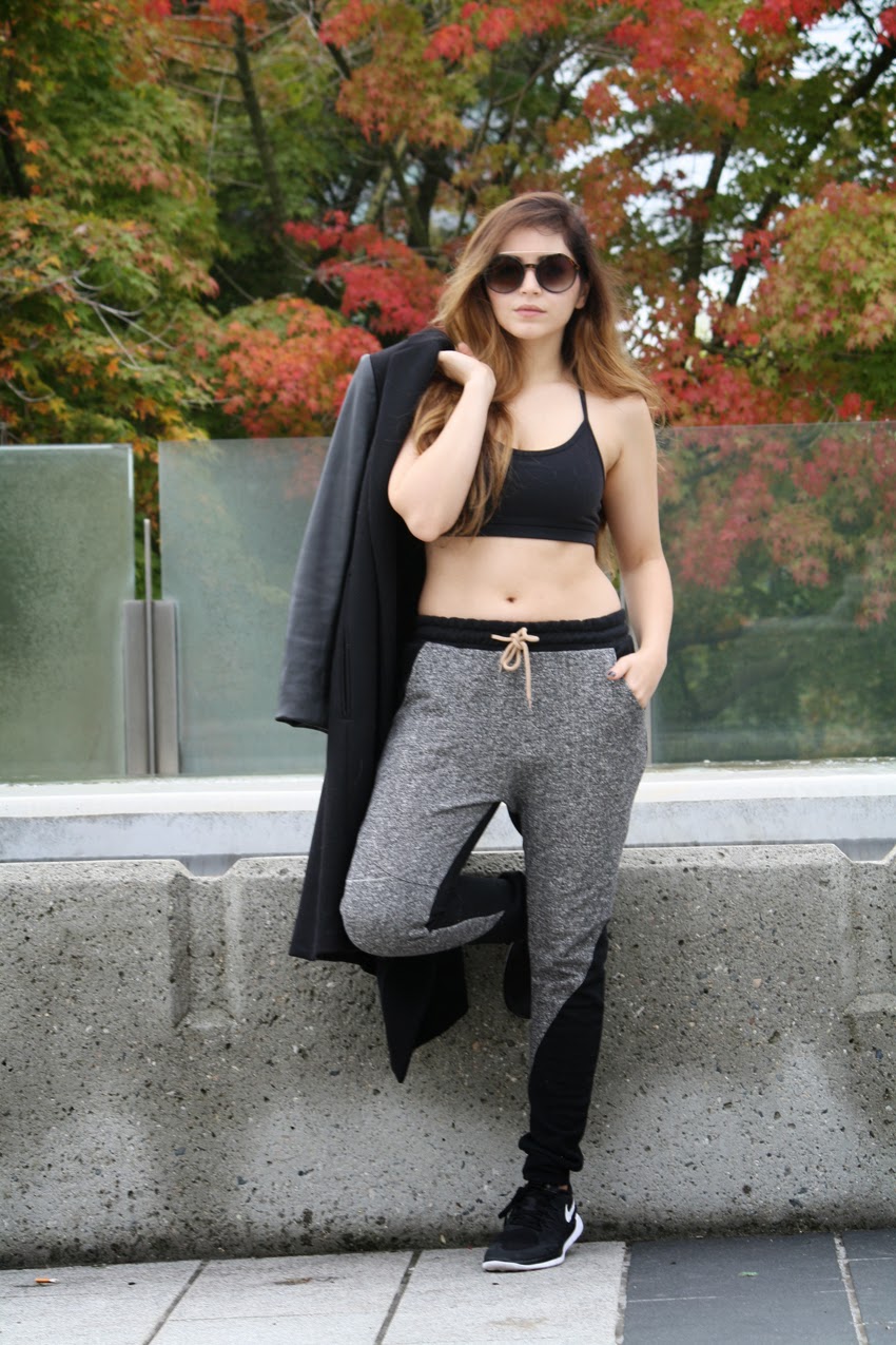 monochrome black and grey sporty casual chic outfit nike sneakers track pants over coat and sports bra