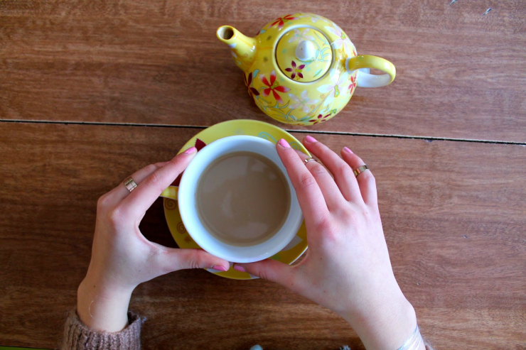 Caramel colored sweater, drinking tea with red lipstick