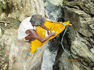 The fisherman collecting his small fish catch from the Duandhar waterfalls stream.