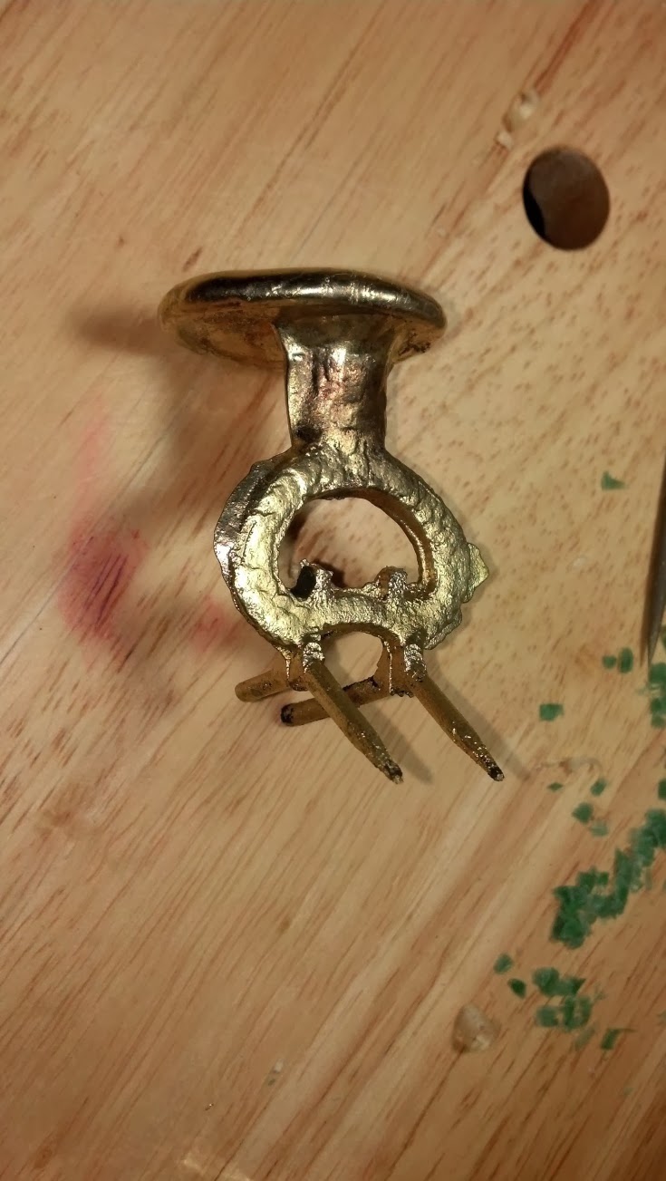 A buckle as it has come from the mold before grinding and polishing.