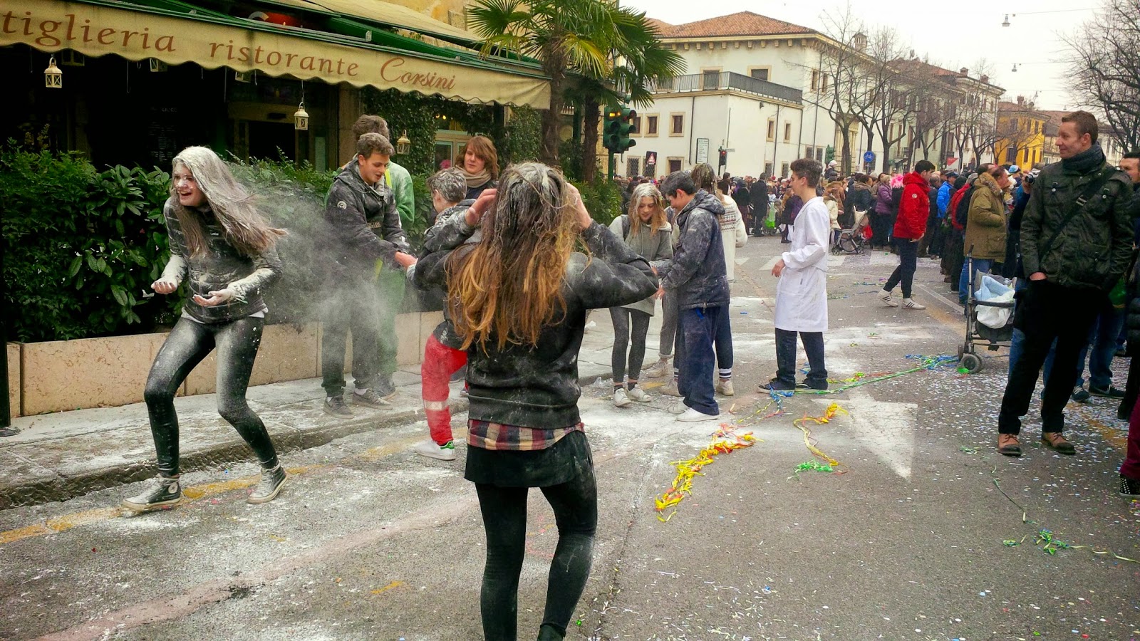 Teenagers throwing flour at each other during the parade for Verona Carnival