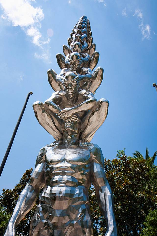 Karma is an intriguing sculptural installation by Korean artist Do Ho Suh that presents countless men sitting atop one another while shielding each other's eyes. Like his Cause & Effect piece, which features a spectacular tornado of figurines, Karma presents figurative sculptures ascending into the sky like a human ladder.