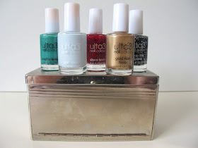 Five full-sized bottles of nail varnish displayed on a metal storage box that looks like a miniature sideboard.