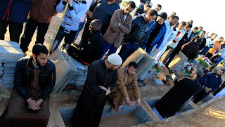 Libyans mourn during the funeral of people who were killed after air strikes, in Tripoli on Sunday, March 20, 2011.