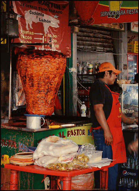Merida Mexico El Pastor meats cooking with food vendor and table