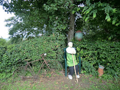 personnage assis près du potager de la petite maison