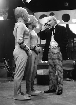 William Hartnell as Dr Who, peers through his monocle at two extra-terrestrials during filming of the popular science fiction series, 'Dr Who' at the BBC's Shepherds Bush Studios in London.   (Photo by Harry Todd/Getty Images)