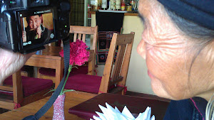 Zwarte Mhong vrouw, 80 jaar, kijkt naar filmbeelden van zichzelf..