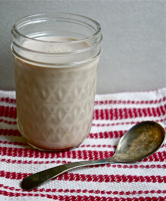 Primal and Paleo Chocolate Syrup in chocolate milk in a jar with an antique spoon