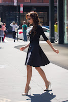 Victoria Beckham crossing the street in short black dress and white high heels