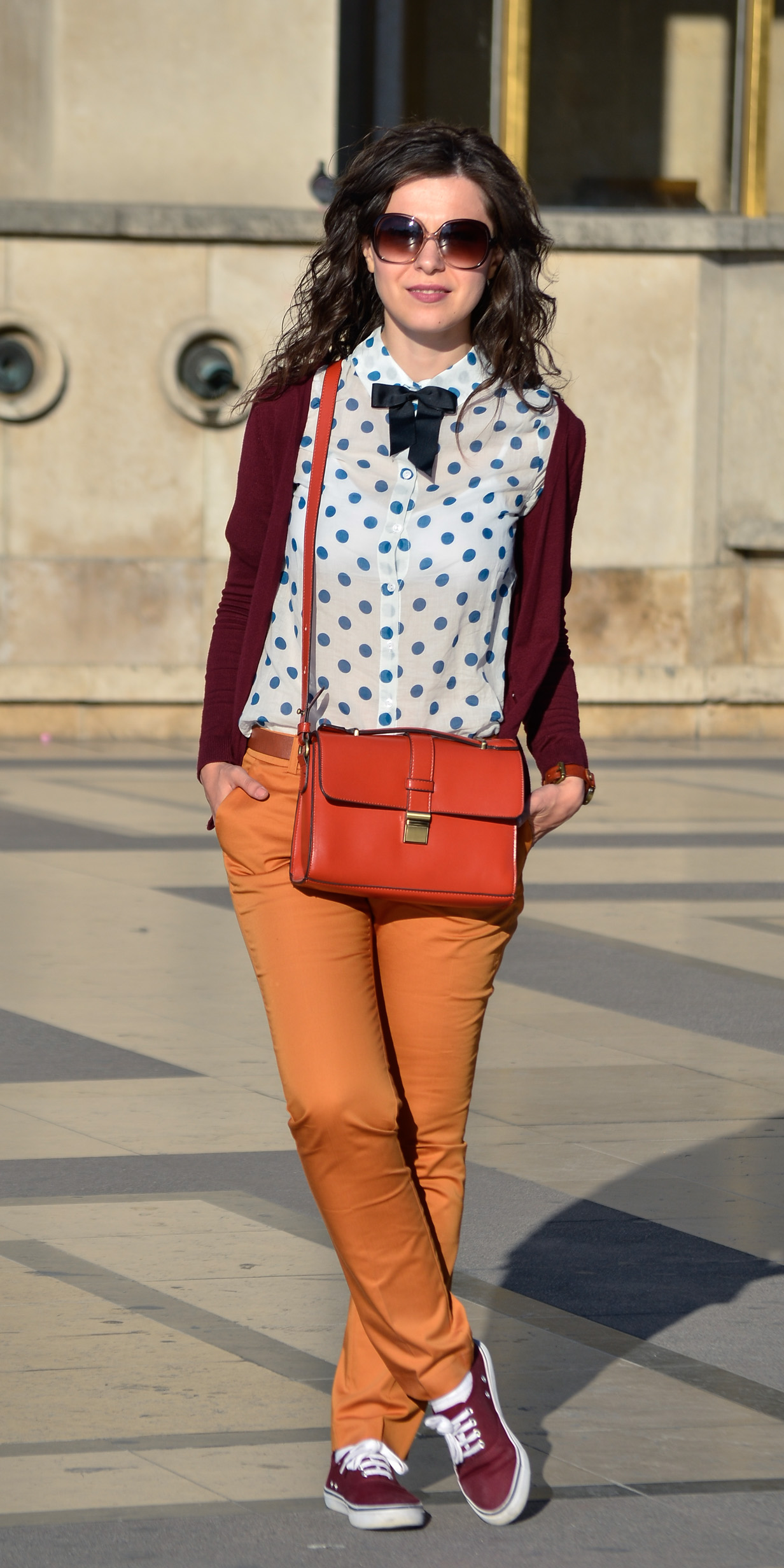 preppy fall outfit in Paris mustard pants burgundy sweater sneakers H&M orange satchel bag dotted shirt blue dots black bow tie champs elysees jardin de tuileries eiffel tower