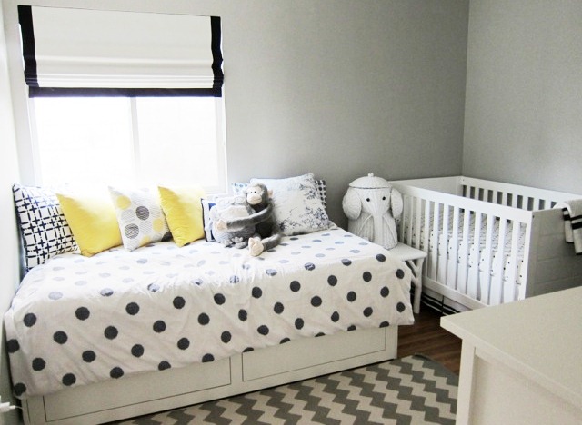 nursery with black and white chevron patterned rug, a twin bed with underbed storage and polka dot bedding, Nbaynadamas accent pillows, a white crib and an elephant hamper