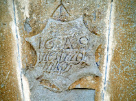 Escut amb inscripció a la clau del portal del Prat Escut amb inscripció a la clau del portal del Prat