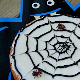cookie decorated like a spider web with fake spiders on it