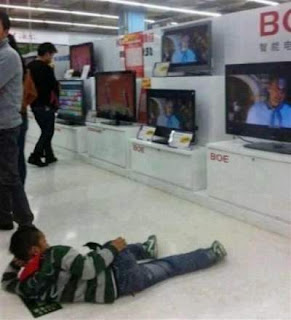 watching television in shopping mall laying on the floor - funny