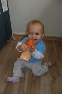 Sitting up and holding the bottle