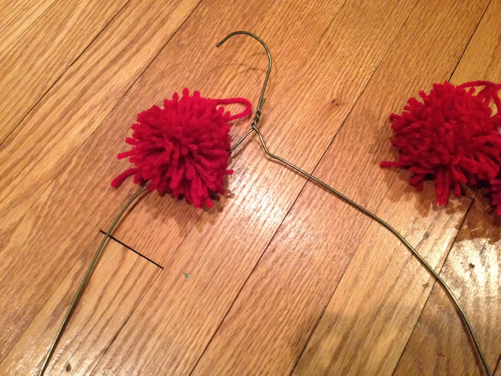 Two It Yourself DIY Pom Pom Yarn Wreath on a Wire Hanger