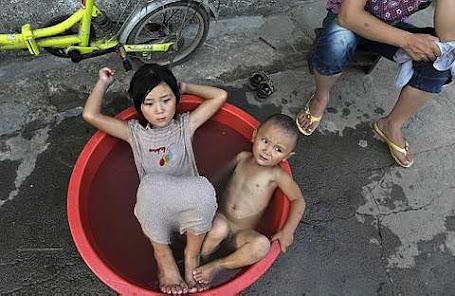 Children sit in a basin filled with water